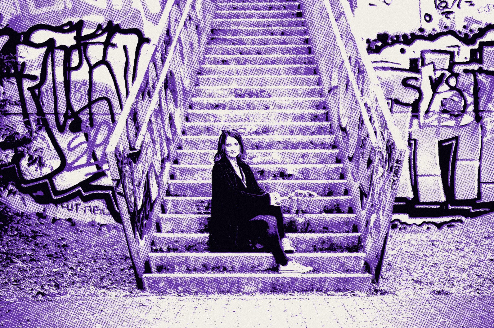 Raphaela Ayriss sitzt auf einer langen Betontreppe zwischen Graffiti-Wänden