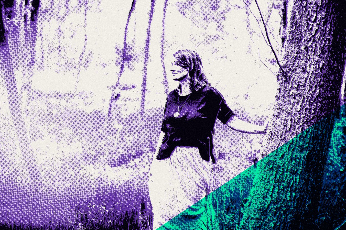 Raphaela Ayriss steht auf einer Waldlichtung an einen Baum gelehnt